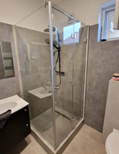 zuhanyfal üvegajtóval sarokba